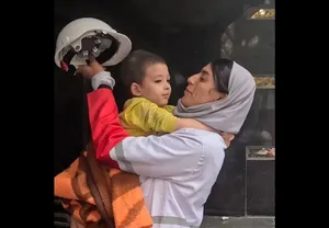 تصاویری از کودک نجات‌یافته از حملات هوایی در آغوش امدادگر هلال‌احمر